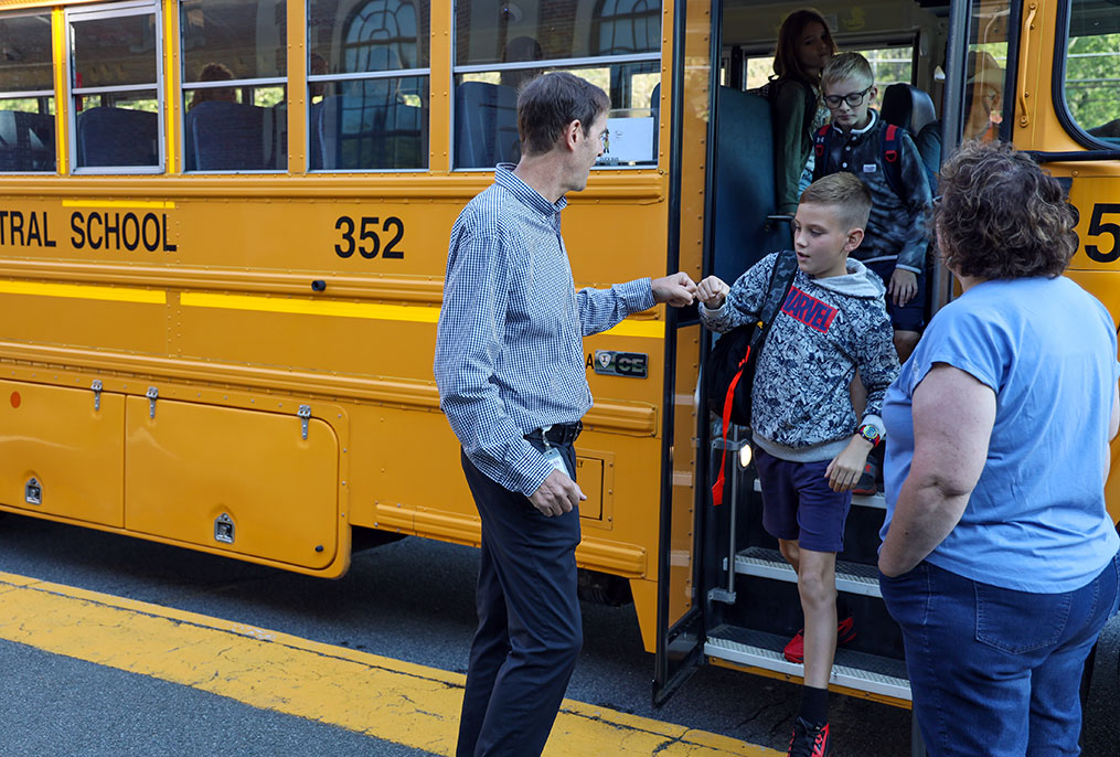 Principal and student doing a fist bump before school