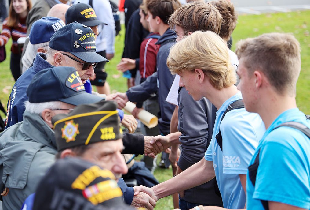 High school students shake hands with veterans