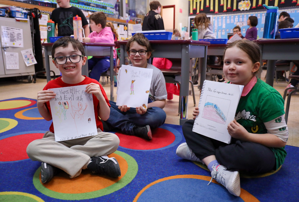 Elementary School students showing their writing assignments.