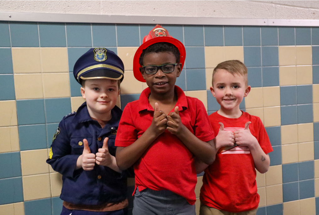 Students dressed up as a cop, and fire fighters for Career Day